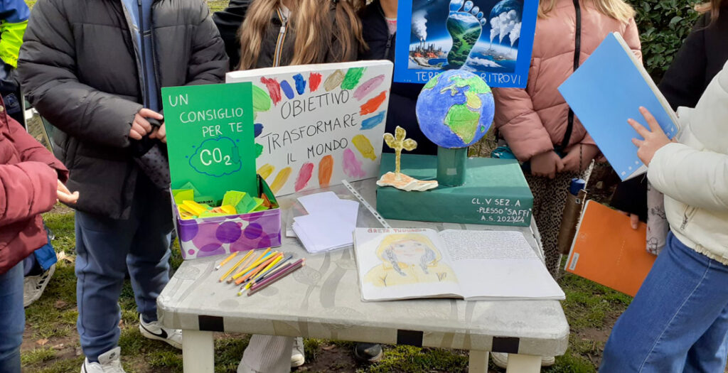 Tavolo con fogli disegnati da bimbi e persone attorno